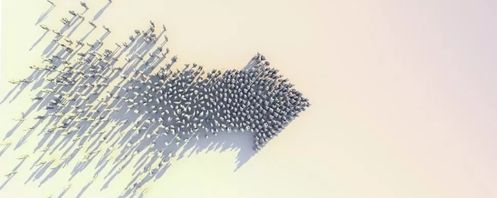 Aerial view of people forming an arrow shape on a white background.