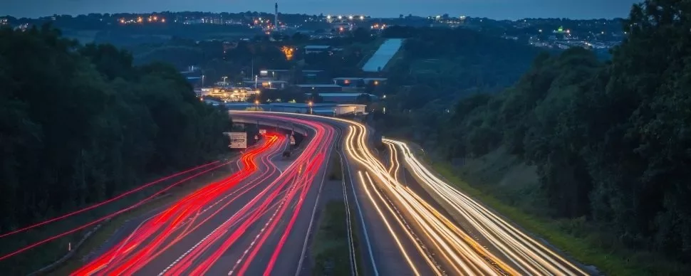 A highway at night with light trails from cars.