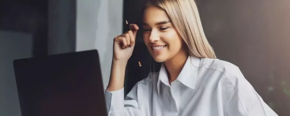 Woman smiling while using a laptop