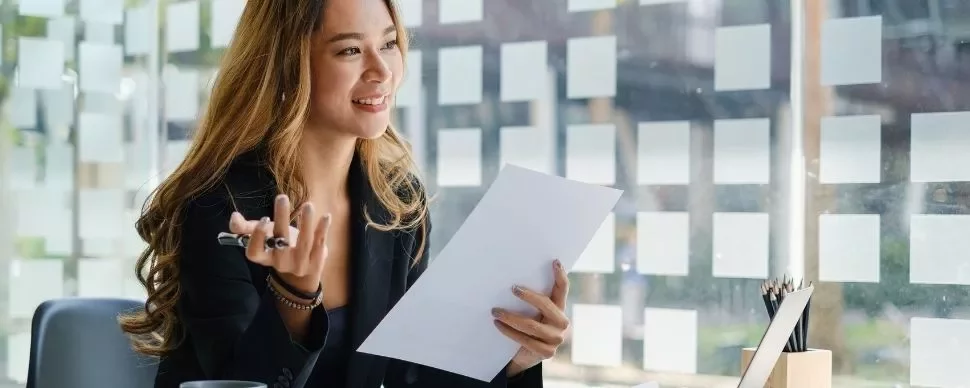 Woman smiling while holding a document in an office
