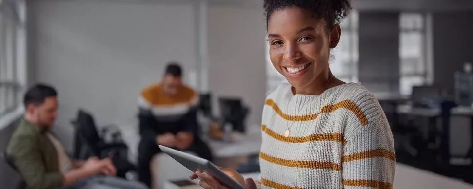 Smiling woman holding a tablet in an office