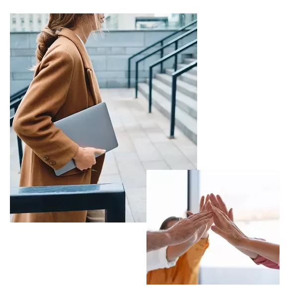 Personne avec ordinateur portable près d’escaliers et collègues se faisant un high-five.