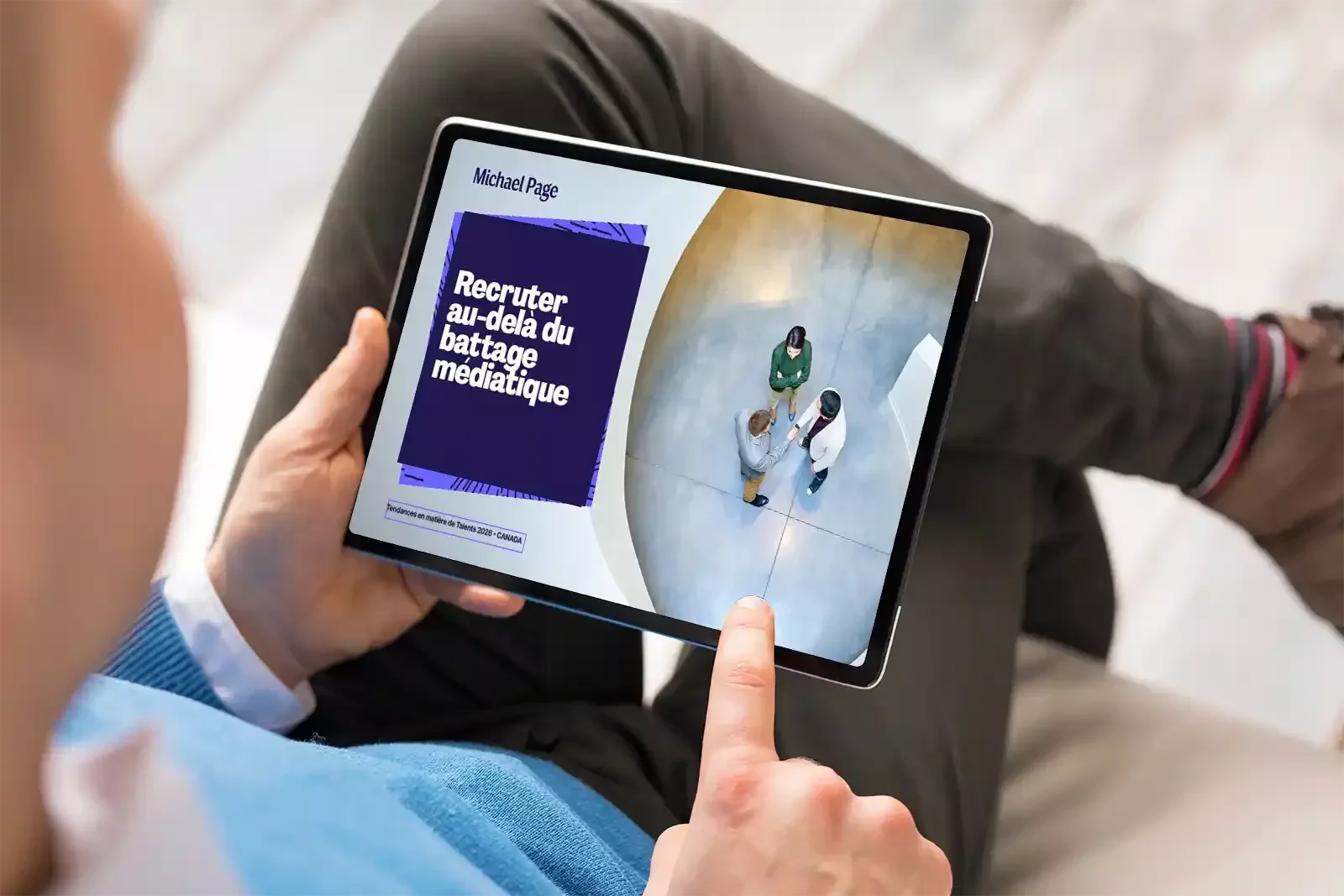 Personne tenant une tablette affichant « Embaucher au-delà du hype ».