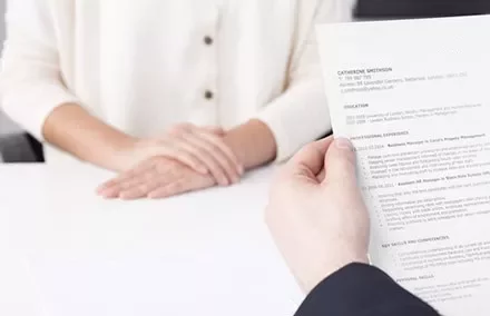 Close-up of an interview with a person holding a resume.