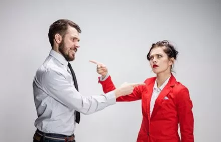 Man and woman pointing fingers at each other.