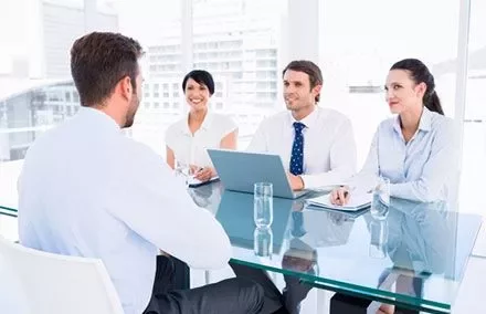 Business meeting in a modern office with four people around a table.