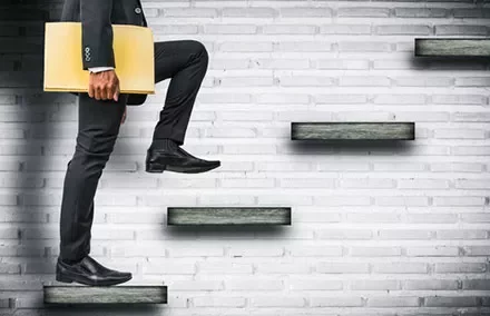 Businessman climbing stairs with a folder.