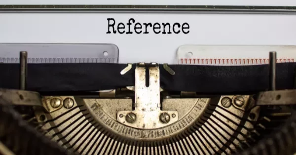 Close-up of a vintage typewriter with the word 'Reference' typed.