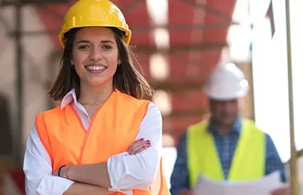 Smiling construction worker in safety gear on site.