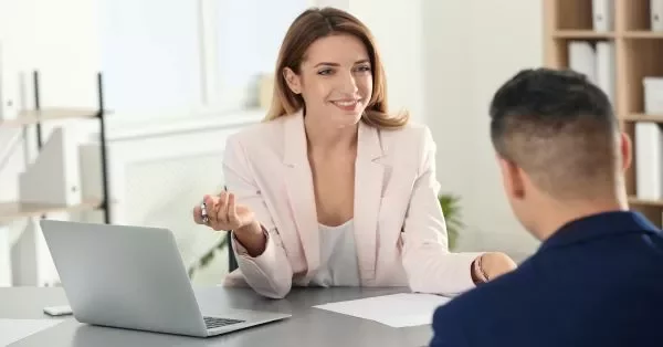 Two people having a conversation in an office setting.